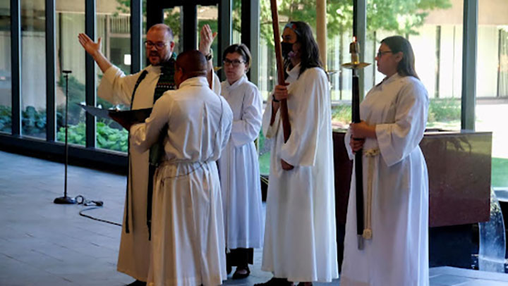 A group in white robes conducting service in the Augustana Chapel