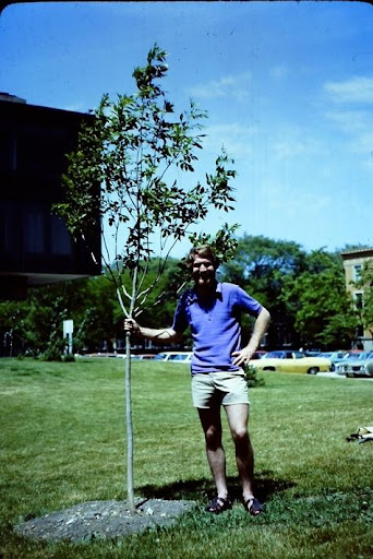 Andy Ballentine posing with a new tree sapling planted in the LSTC courtyard