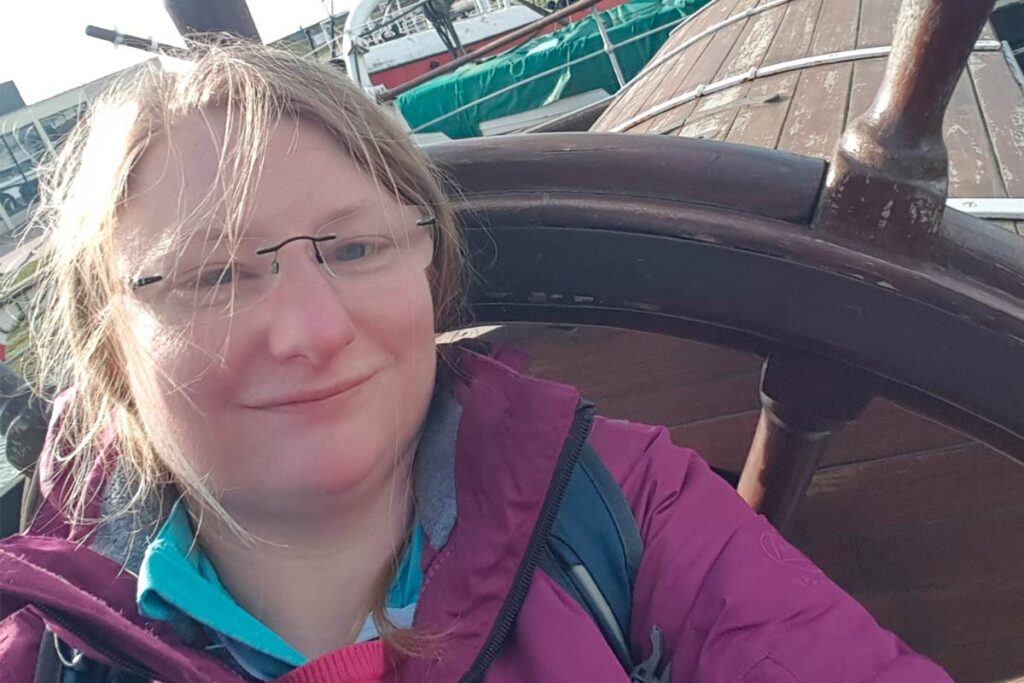 Mariam Schmidle posing at the helm of a boat