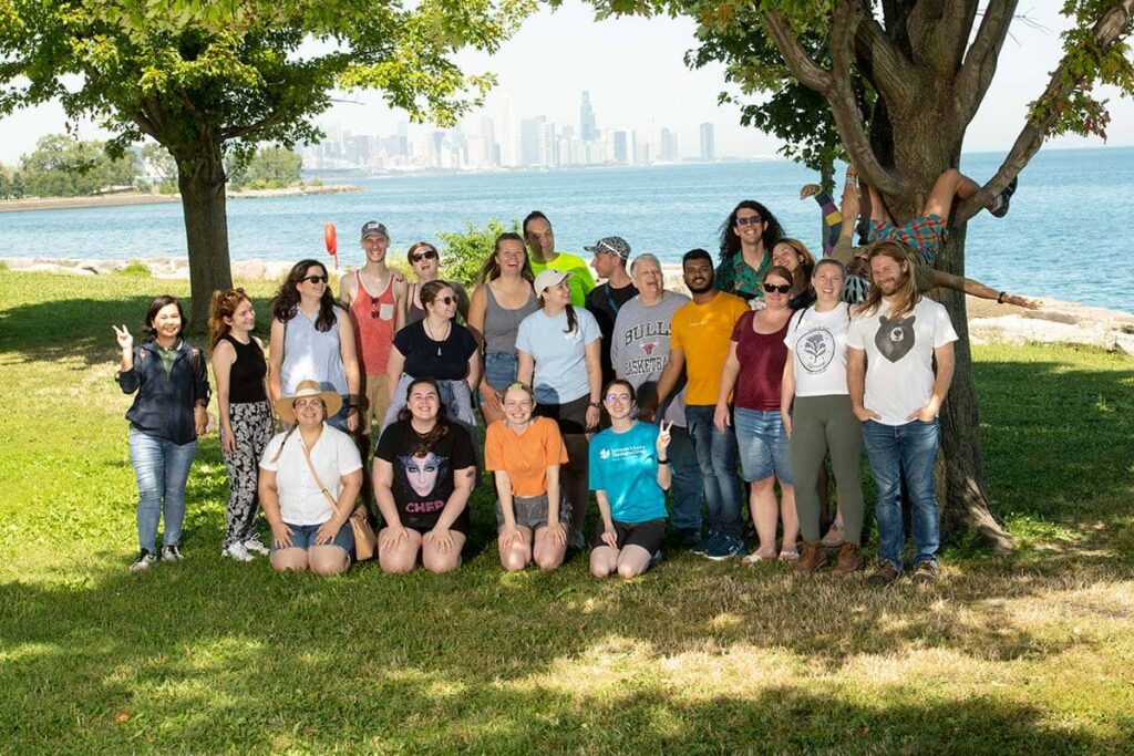 A group of new students pose on Promontory Point with the Chicago skyline in the background