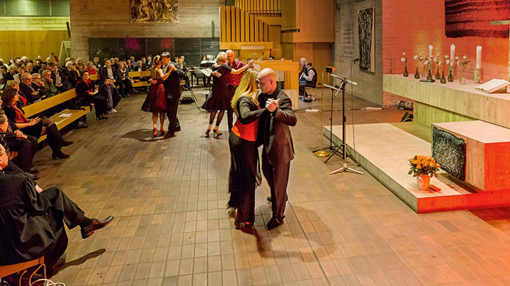 Three couples dancing in front of an audience in a church