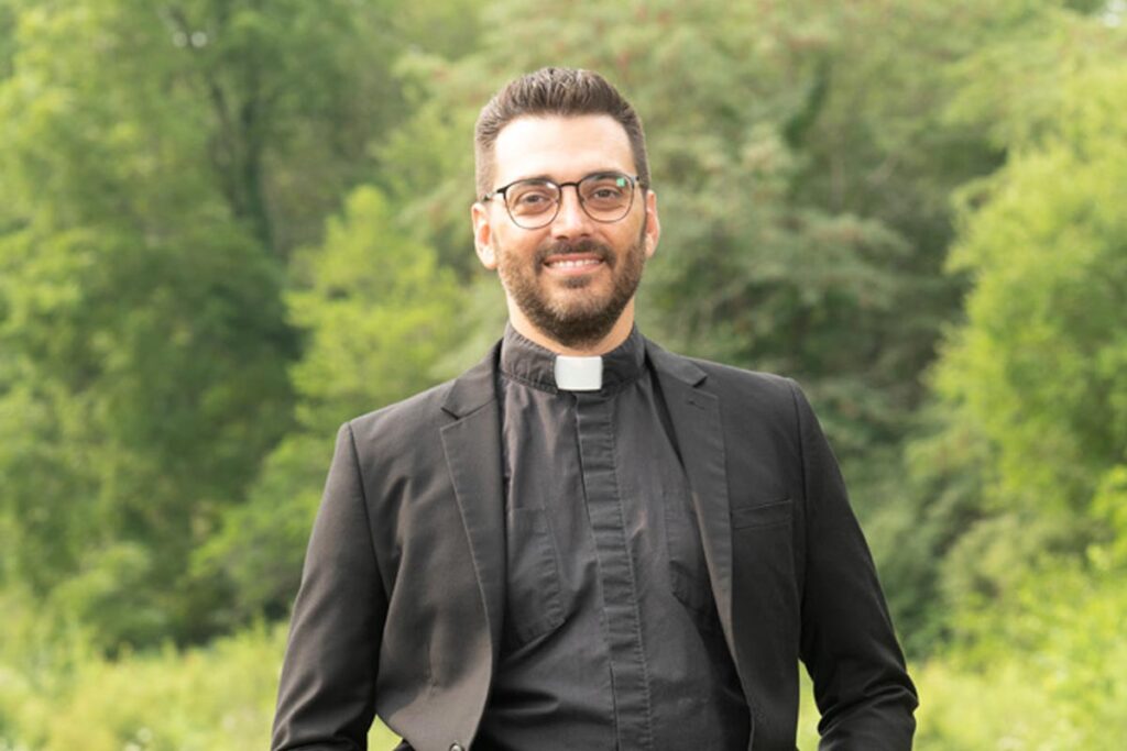 Clark Olson-Smith, MDiv ’06 wearing his clerical collar and smiling