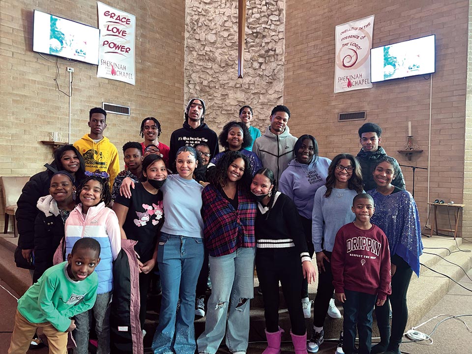The Youth Ministry 
at Shekinah Chapel where 
Shemiah and her sister, Shekinah, 
are the co-leaders. A crowd ranging from children to teenagers pose at the front of a church.