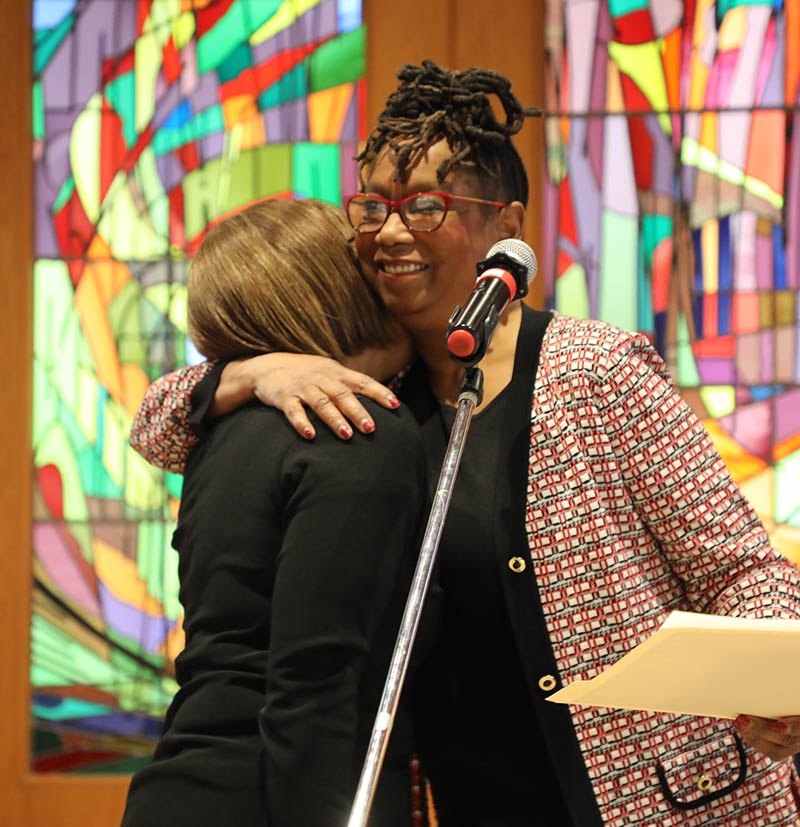 Dr. Linda Thomas giving a hug at the Gospel Choir Benefit Concert.