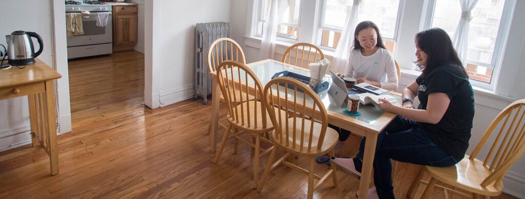 Two LSTC students studying at their dining room table.