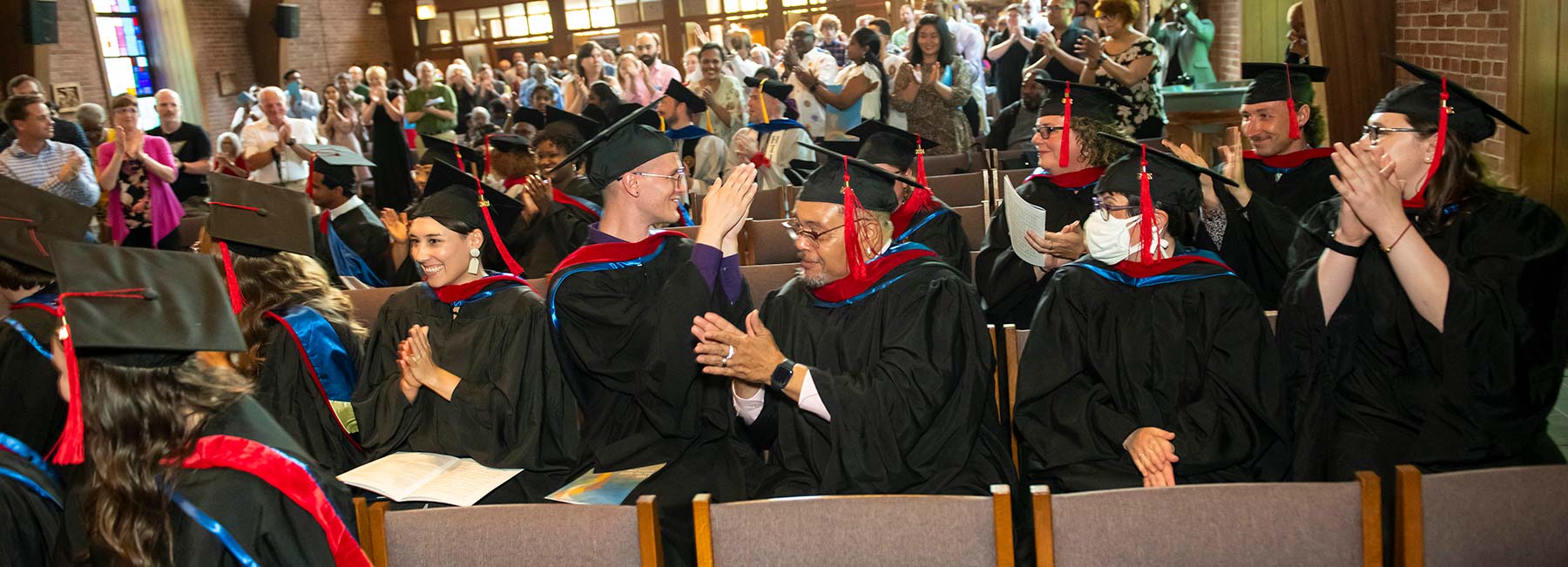 LSTC graduates applaud along with the audience at commencement.