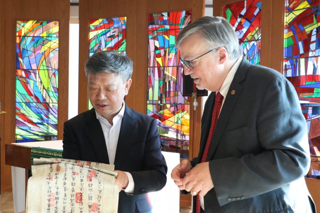 President Jim Nieman observes a tapestry with Chinese writing on it.