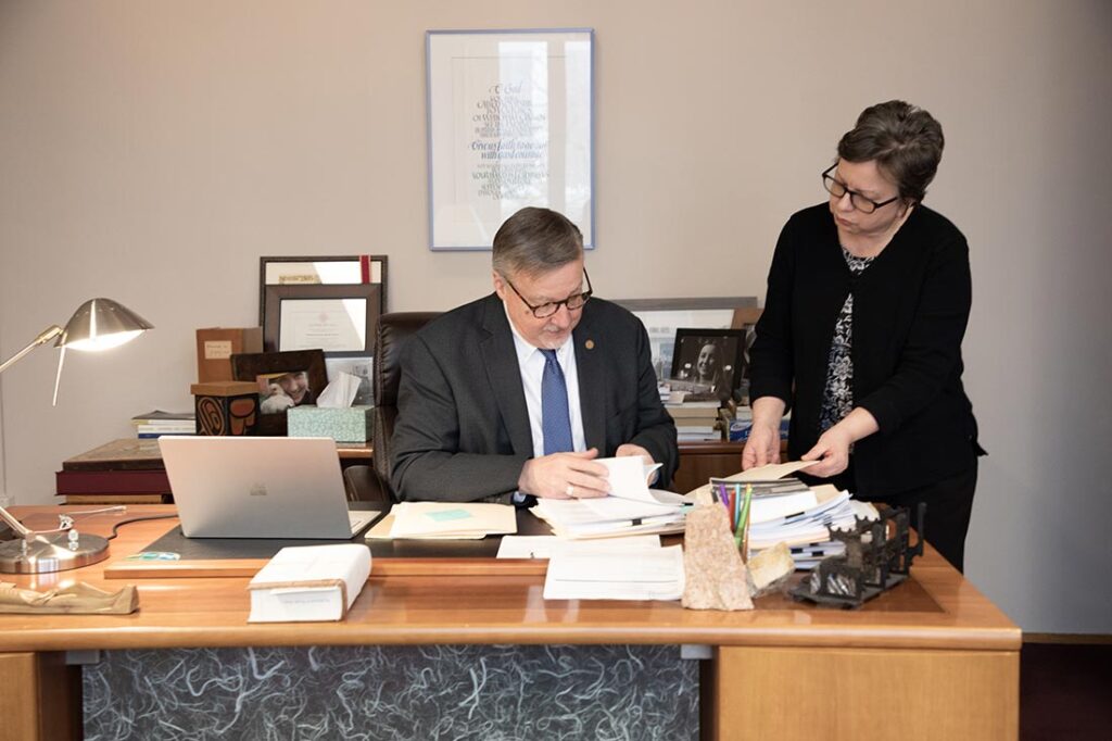 President James Nieman and an assistant look through paperwork.