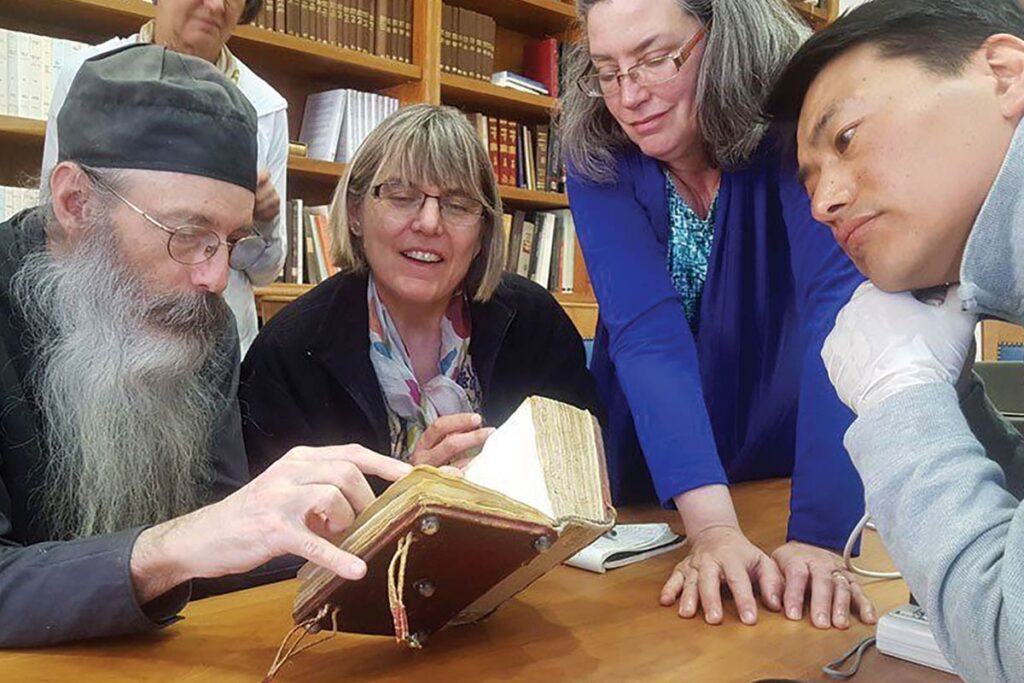 At the library of St Catherine’s Monastery in Sinai, Egypt, in 2018, Father Justin shows an 8th century Arabic biblical manuscript to LSTC PhD student Yoseob Song and Professors Barbara Rossing and Esther Menn.