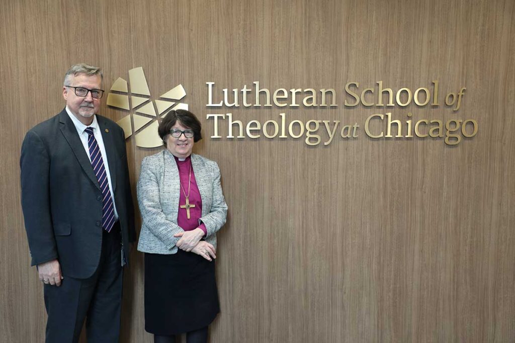 Bishop Elizabeth Eaton and President James Nieman posing in front of a wall-mounted LSTC logo.