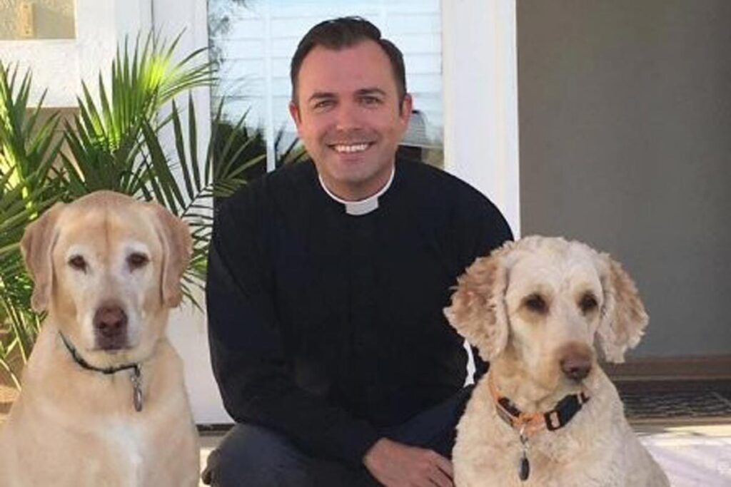 Reverend Preston Fields posing with two dogs.