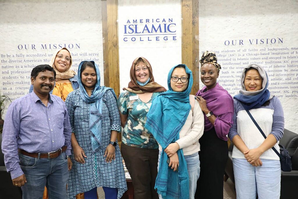 Sara Trumm posing with students during a visit to American Islamic College.