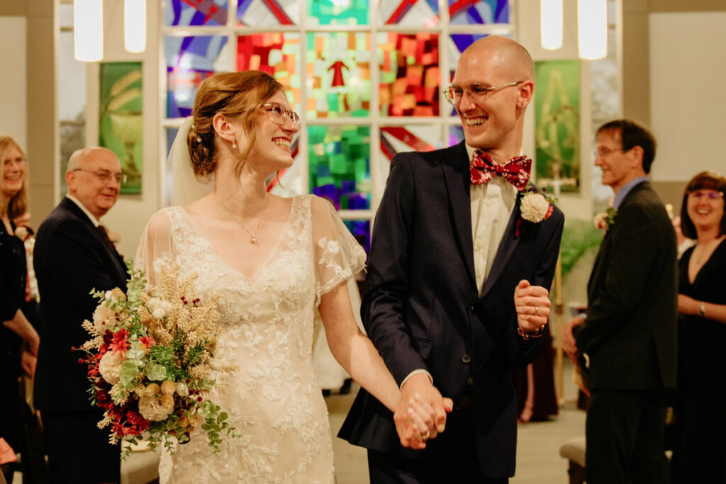 Katie and Eric Jensen walking down the aisle at their wedding at St. Stephen Lutheran Church in Urbandale, Iowa.