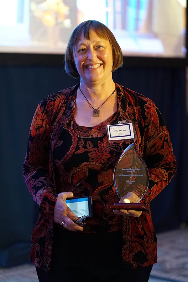 Sara Trumm holding her community champion award.