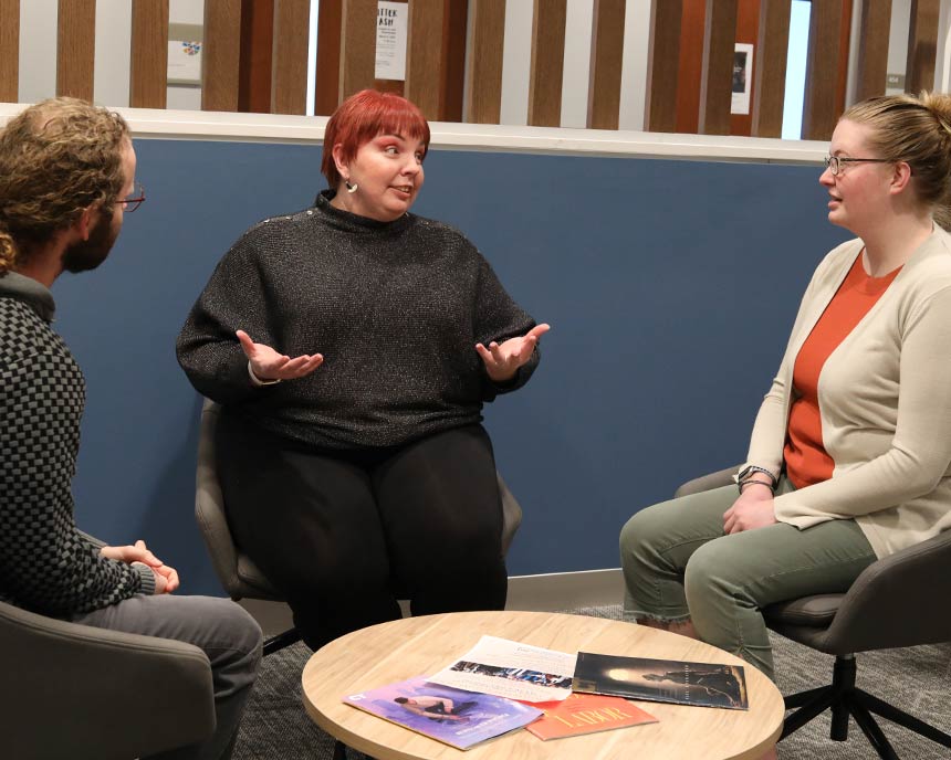 LSTC faculty member Dr. Karri Alldredge having a lively conversation with two students in the lounge.
