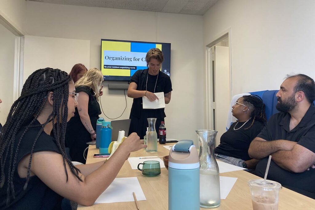 LSTC student Hannah Peterson leads a group of organizers in a conference room.