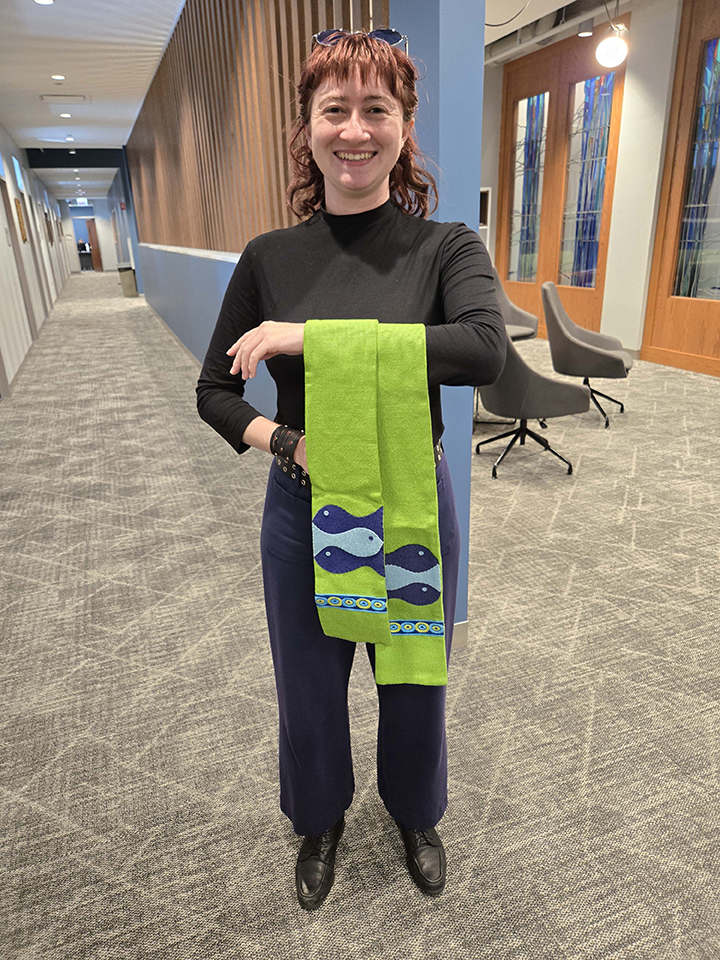 LSTC student Alex Clark holding stoles.
