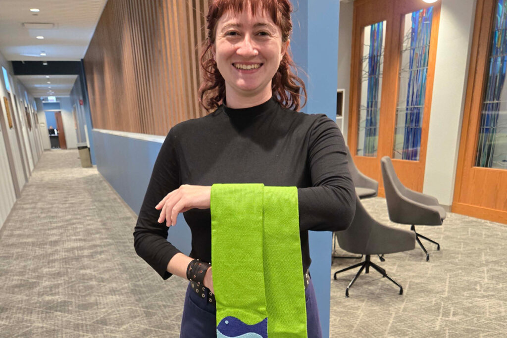 LSTC student Alex Clark holding stoles.