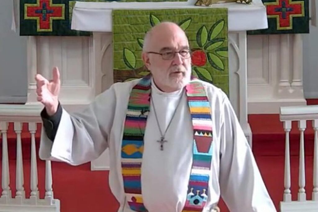 Tom Hiller preaching at the front of his congregation.