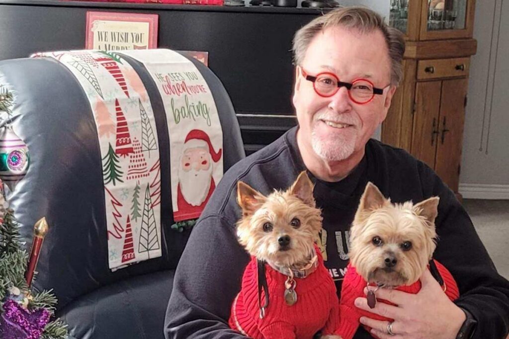 Jeffrey Nelson posing with his two dogs.