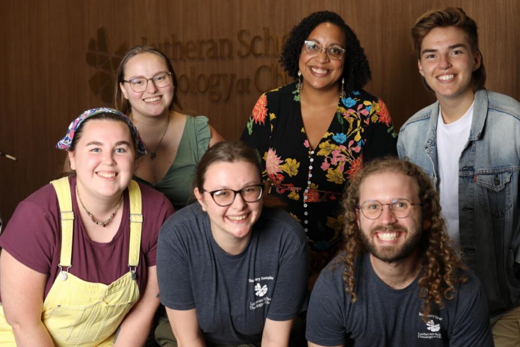 A group of students pose in front of LSTC signage at the Seminary Sampler event.