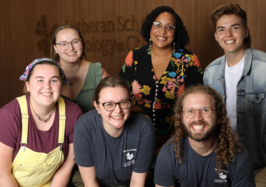 A group of students pose in front of LSTC signage at the Seminary Sampler event.