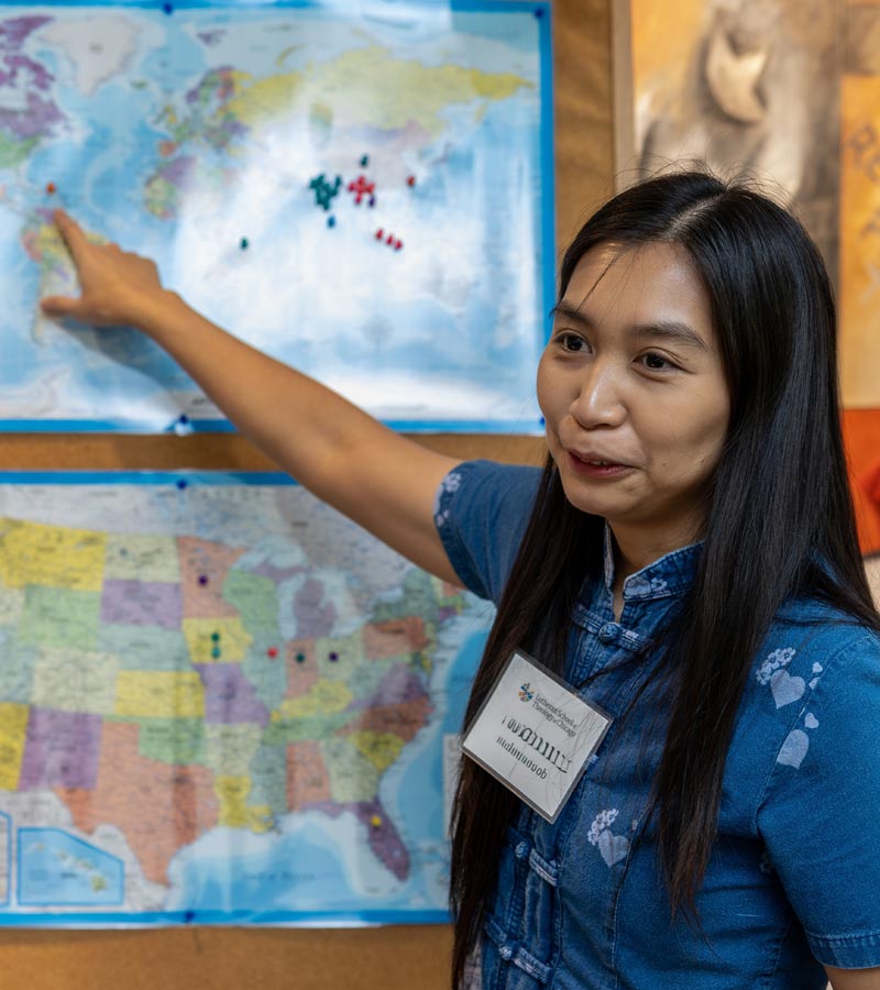 An LSTC student point to the Caribbean on a world map.